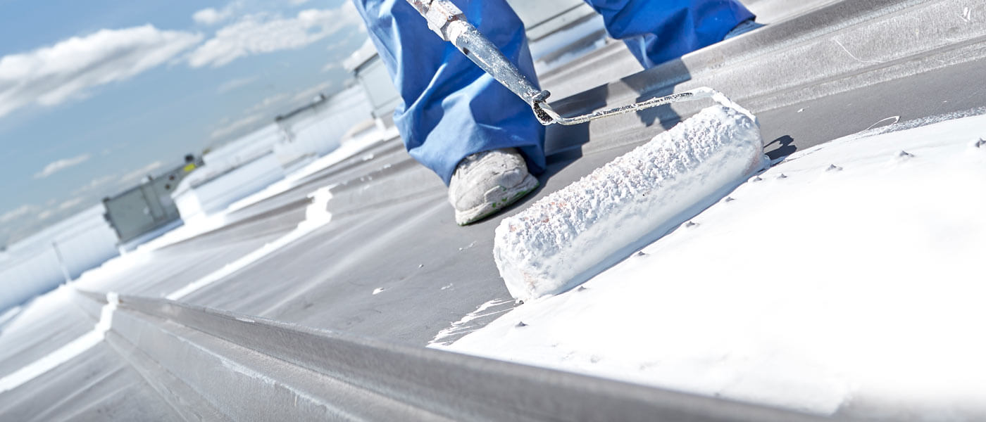 crew-applying-roof-coating-on-commercial-metal-roof Crew applying roof coating on a commercial metal roof