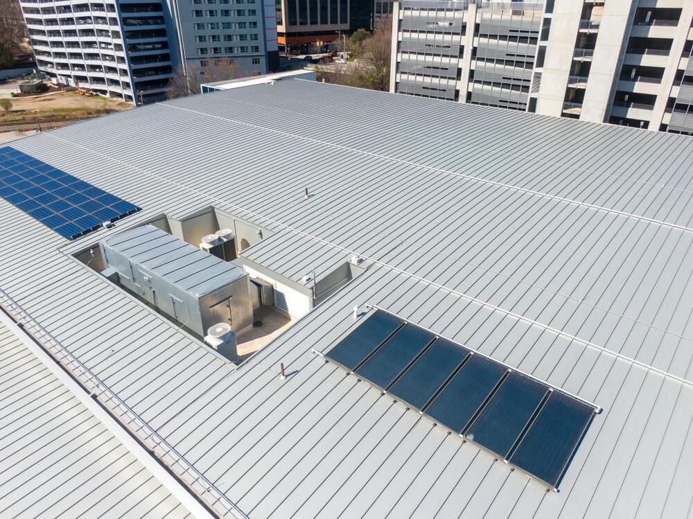 A commercial metal roofing system with solar panels on a commercial building