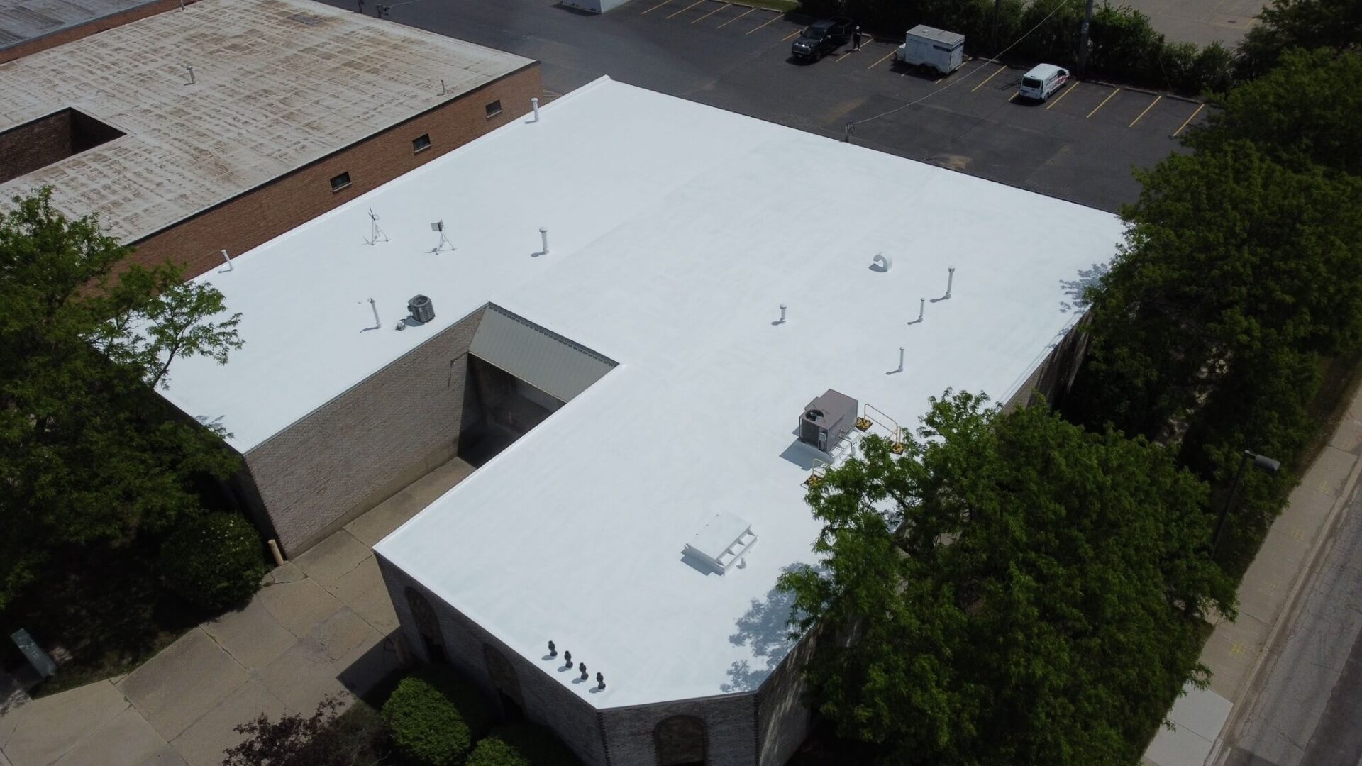 Aerial view of a TPO commercial flat roof with rooftop units, ideal for flat roof restoration, repair, and maintenance.