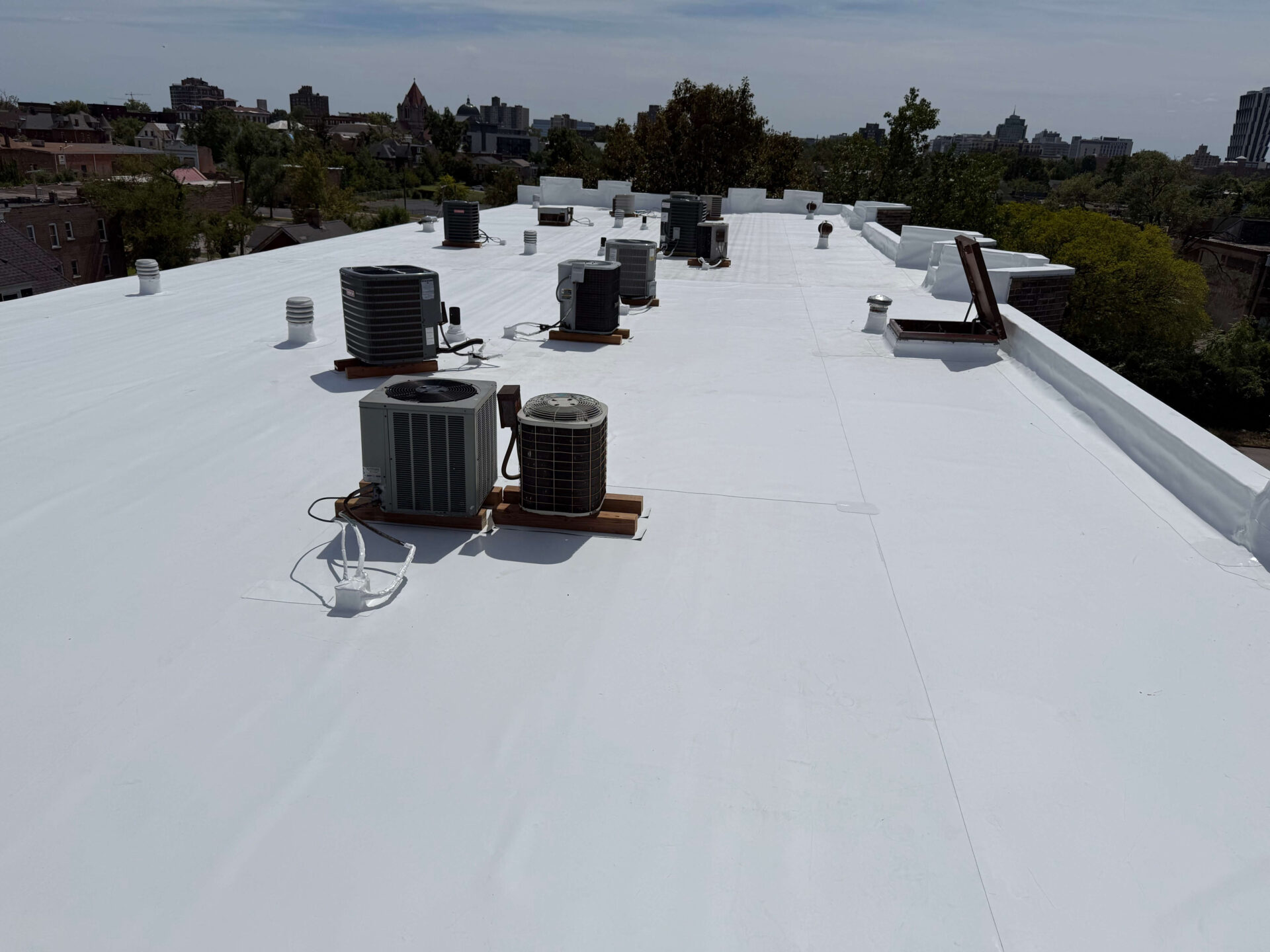 Commercial flat roof with HVAC units, showcasing TPO flat roof, vents, and maintenance.