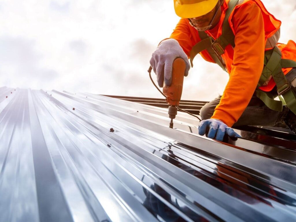 Roofer anchoring a single-ply-roofing-membrane