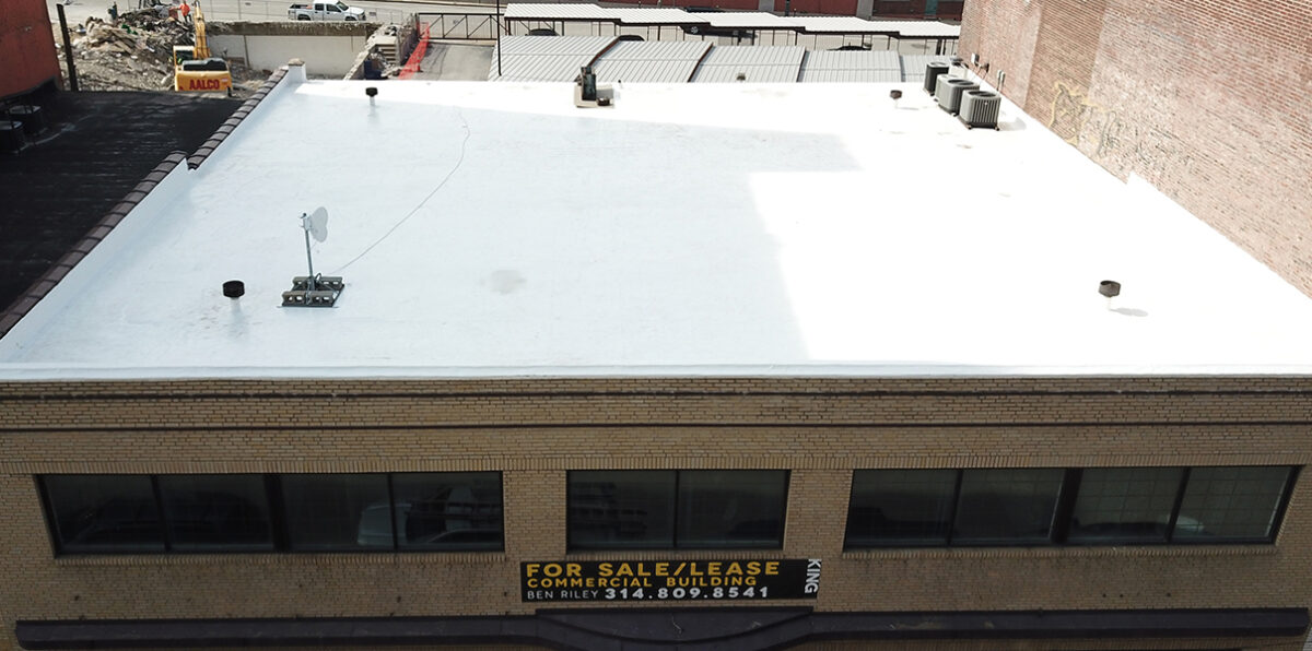 Commercial flat roof after roof coating restoration with seamless white reflective coating