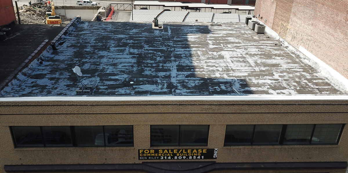 Aged commercial flat roof before roof coating restoration showing worn and weathered surface
