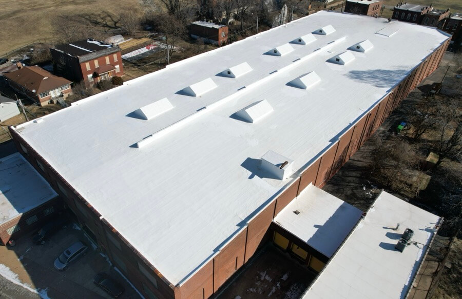 commercial flat roof replacement completed on large industrial building with white membrane roofing system