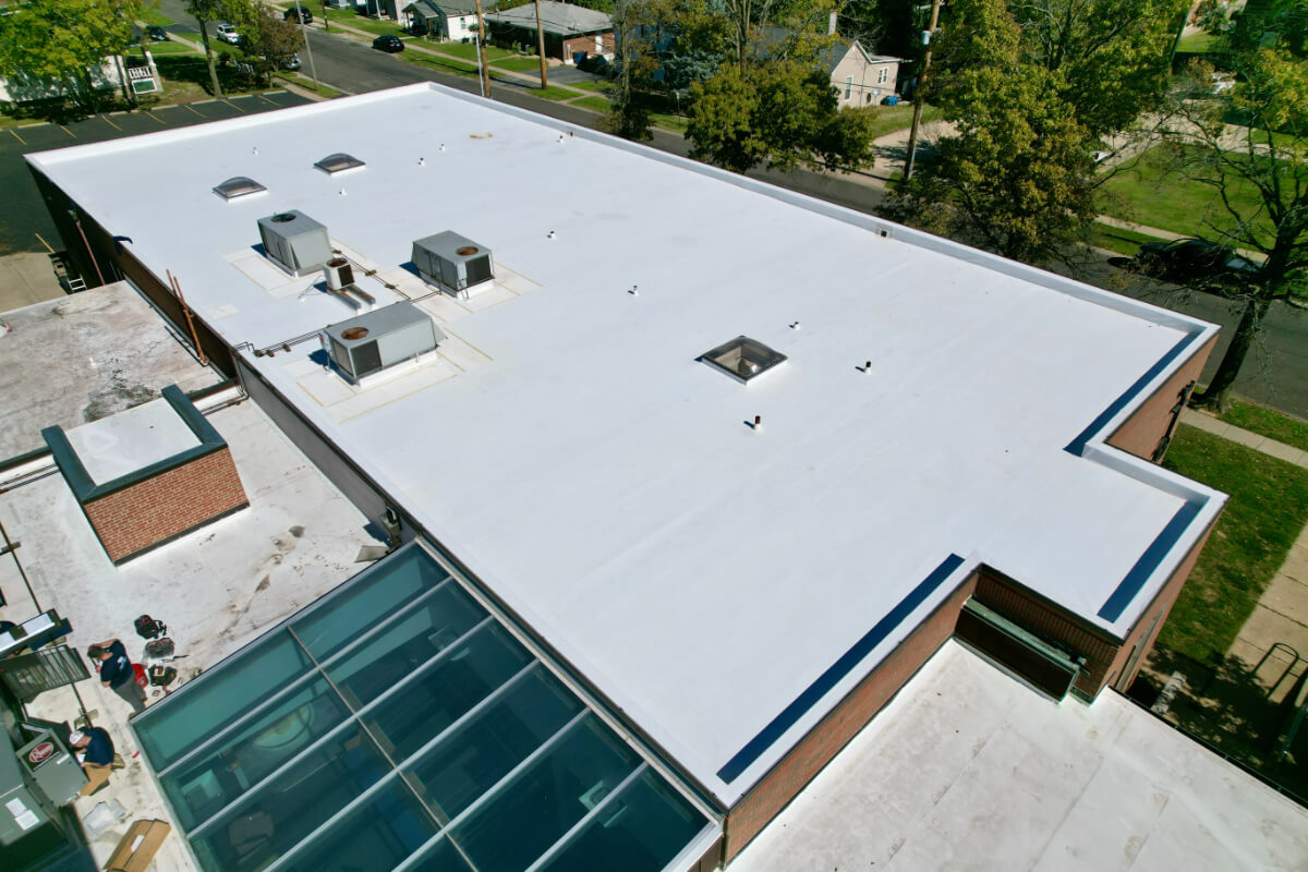 Commercial flat roof with white TPO membrane installed on low-slope building