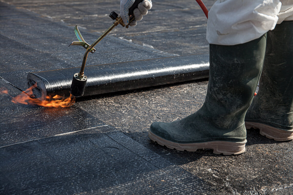 torch-applied-modified-bitumen-roof-installation-98 Contractor installing torch-applied modified bitumen roofing membrane on commercial flat roof