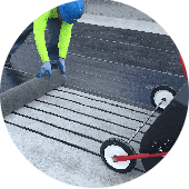 img-restore-your-roof Worker installing a mat over heating cables during commercial flat roof restoration.